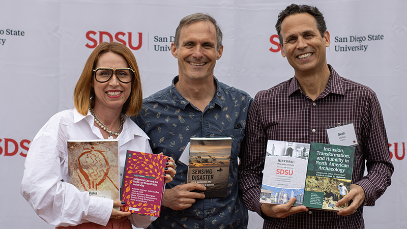 Three authors holding their books