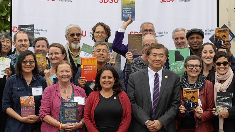 Large group shot of authors holding their books smiling
