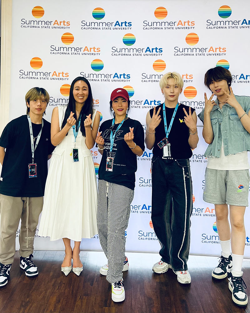 Chuyun Oh stands with K-pop dance instructors at the CSU Summer Arts class.