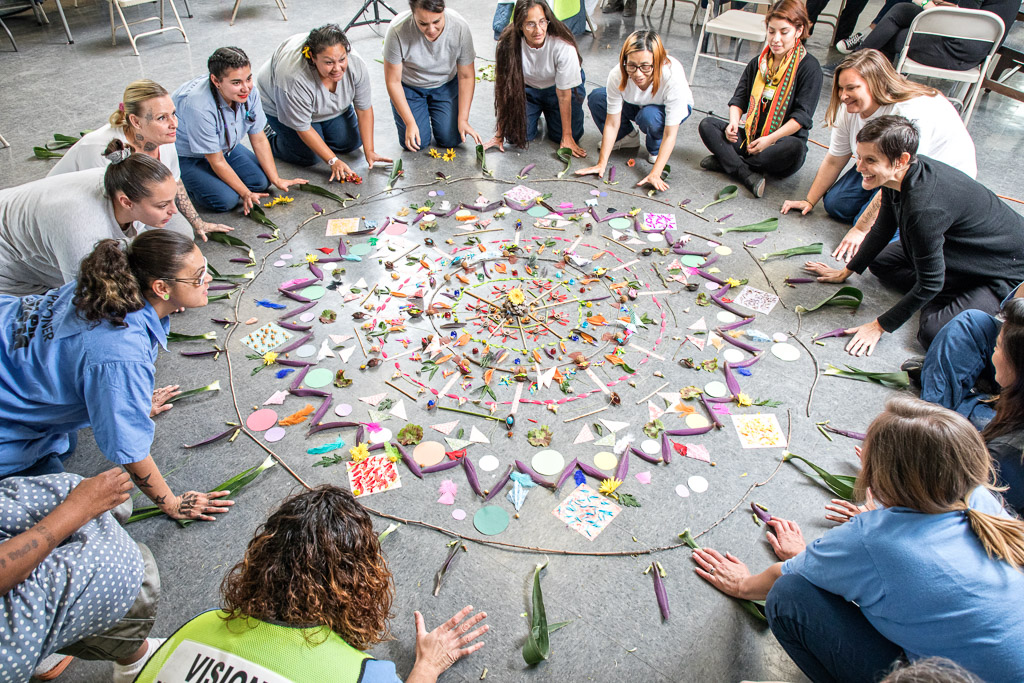 Annie Buckley, right, works with participants at the California Institution for Women during a collaborative mandala project. 