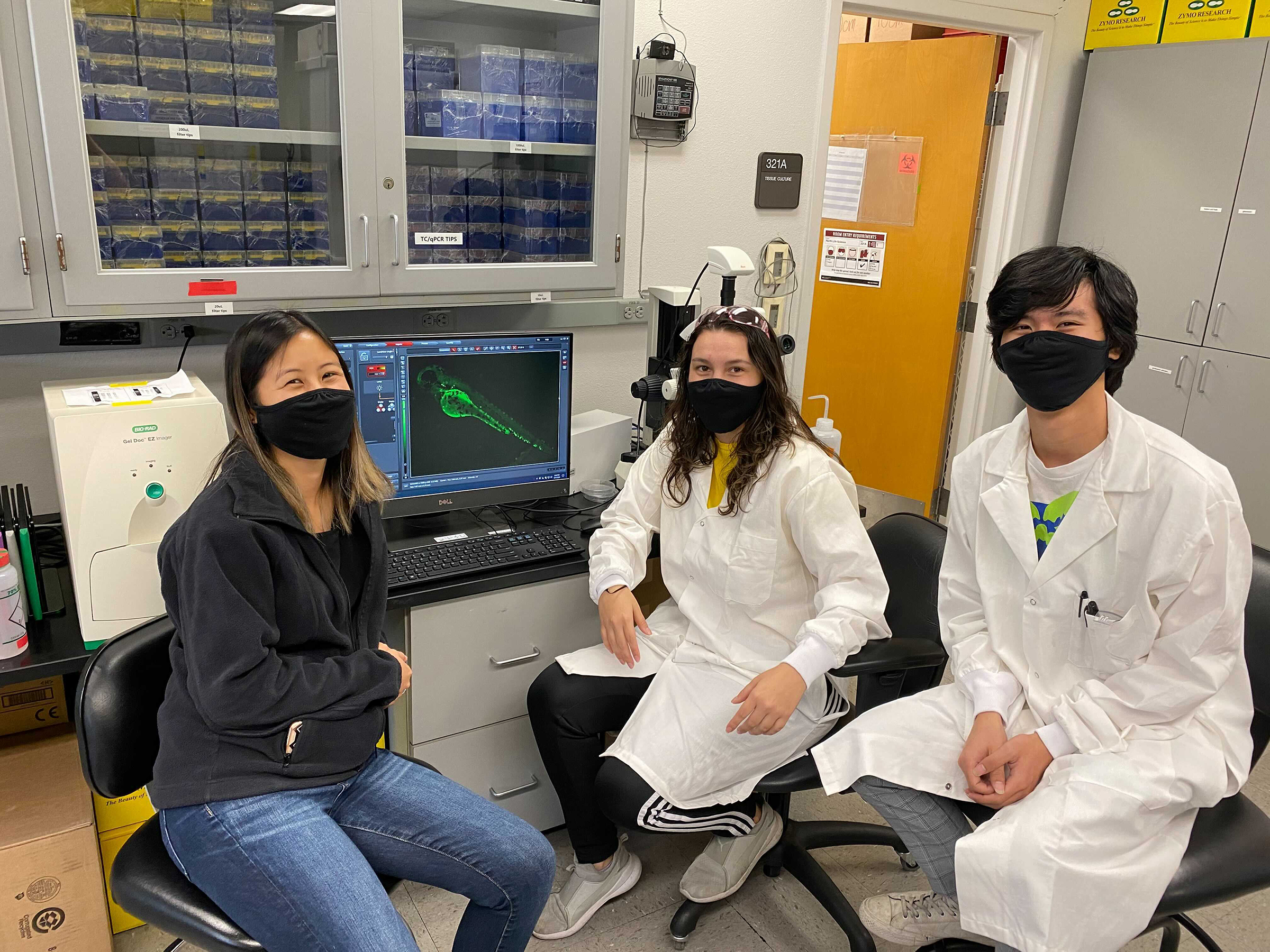 Nikki Nguyen and Jasmine Chavez with a glowing zebrafish embryo.