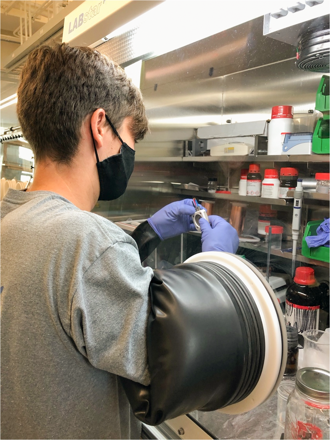 Ph.D. student Alex Aleshin working in the glovebox which keeps reactive battery materials usable and safe to work with.