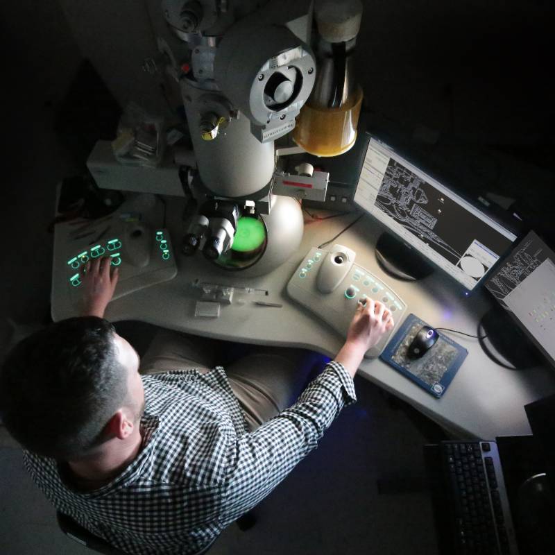 man operating electron microscope